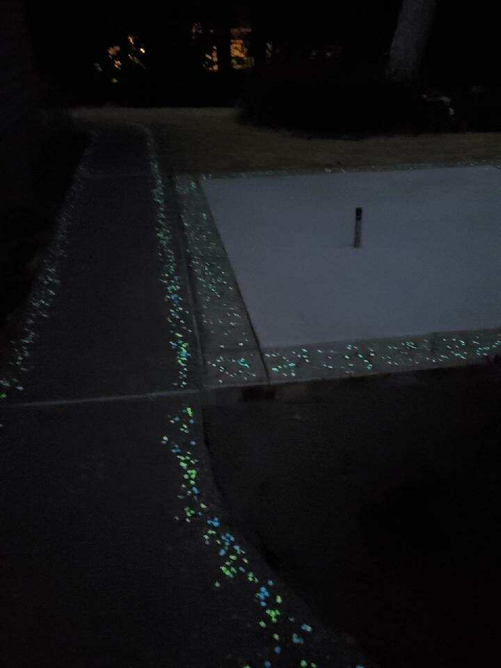 Glow-in-the-dark trim on a concrete walkway at night